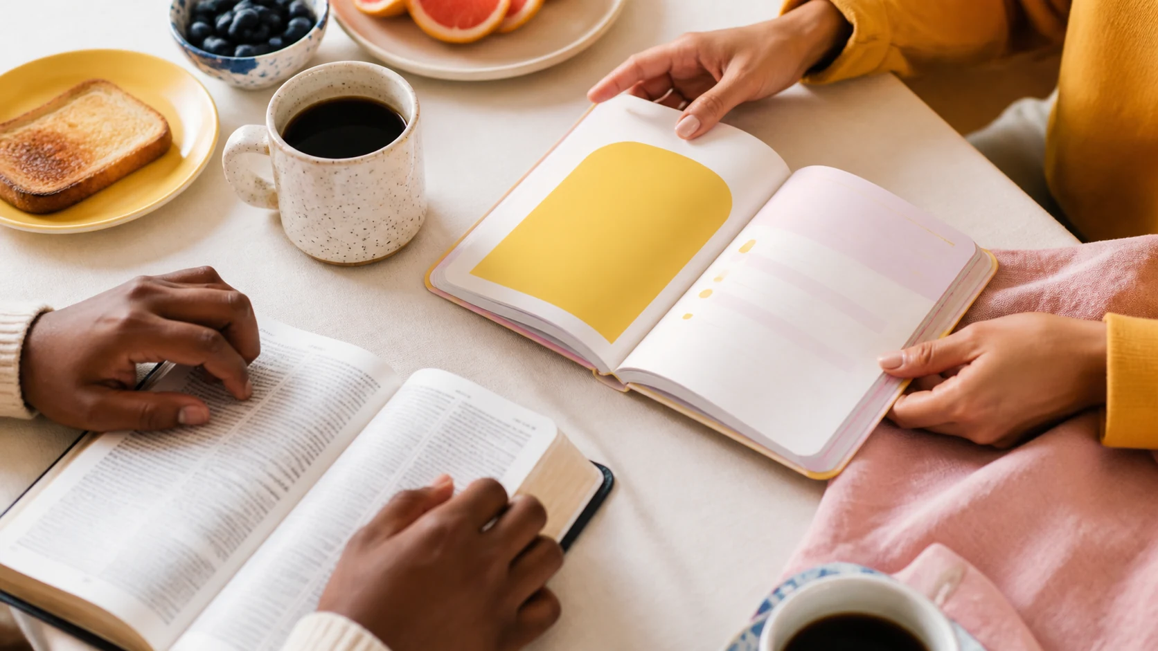 Two people sharing an open NobNob devotional at a breakfast table